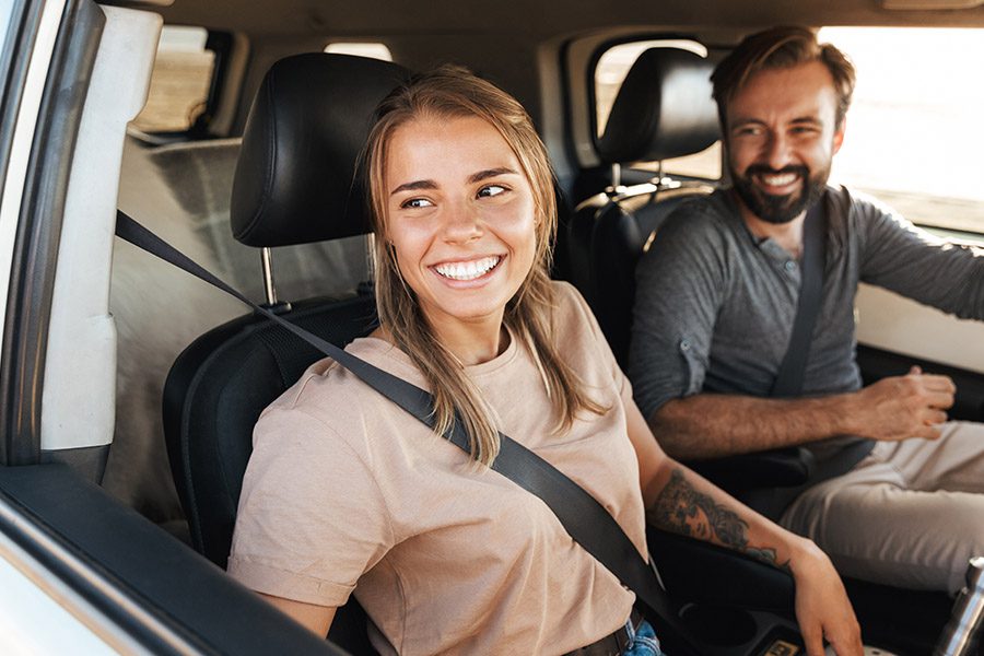 Personal Insurance - Close-up of a Smiling Young Couple Sitting in Their Car Getting Ready for a Drive Along the California Coast at Sunset